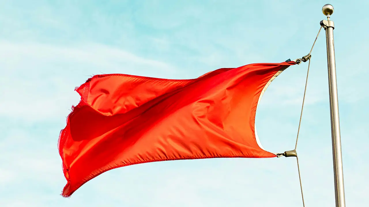An image of a red flag waving in the wind.